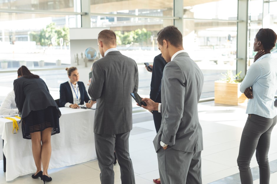 Recepção de eventos: terceirizar é o melhor para não cometer erros Equipe de colaboradores de uma empresa de facilities realizando uma recepção de eventos em uma organização contratante.